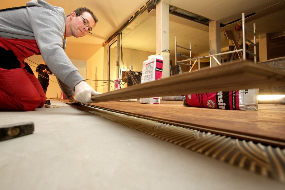 Až 3,5 m dlouhé parketové lamely jsou opatrně položeny na vrstvu lepidla