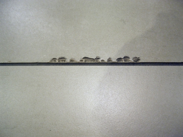 Obr. 3: Čím menší velikosti dlaždic, tím větší je počet dlaždic a spár, které přicházejí do styku s dráhou koleček. Obrázek ukazuje příklad „poškozených dlaždic“ a „vypadlé“ malty ze spár.
