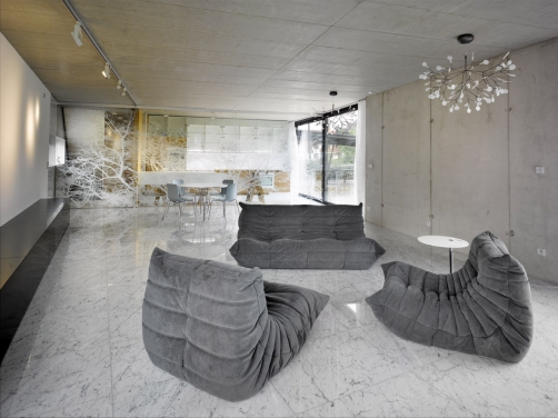 V hlavním obytném prostoru je podlaha z bílého mramoru, stěny a stropy z pohledového betonu