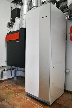 Obr. 18: Technické zázemí, vlevo jednotka VZT s tlumiči hluku („rozšíření trubek“) a předehřevem vzduchu („černá krabička“), vpravo tepelné čerpadlo se zásobníkem TUV