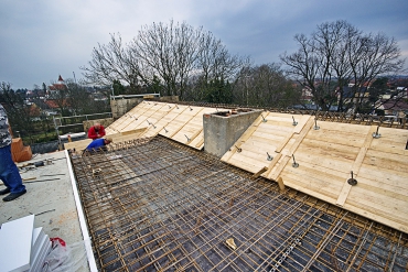 Z průběhu realizace střechy nad historickou budovou – šikmé části střešní desky se prováděly do oboustranného prkenného bednění s poměrně složitou podpůrnou konstrukcí