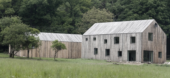 Dřevěný obklad domů je z nehoblovaných modřínových prken s oblinami bez jakékoliv povrchové úpravy