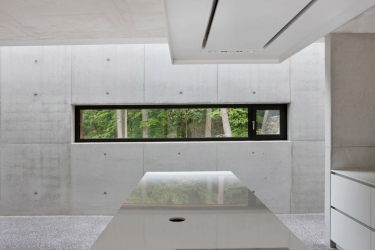 Obr. 9: Pohledový beton je dominantním prvkem interiérového designu. Vidět je z části otvíravý okenní element ze systému Schüco AWS 75.SI.