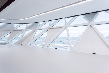 Směs prosklených a neprůhledných fasádních jednotek opticky zkresluje objem budovy, jejíž transparentní povrch se mění v závislosti na intenzitě denního světla