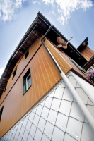 Prefa Sidings s optikou dřeva v kombinaci s bílou fasádní šablonou na horské chatě. Vhodné pro rekonstrukce s minimálními nároky na následnou údržbu. Cena Prefa Sidings je od 850 Kč/m² a fasádní šablona od 696 Kč/m².
