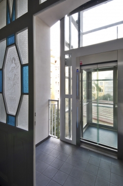 Mezipodesty s novým výtahem: design výtahové šachty i kabiny je prosklený a odlehčený, aby co nejméně omezil prosvětlení stěn se secesními motivy