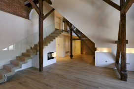 Schodiště v mezonetovém bytě má konstrukci s ocelovými schodnicemi, stupni z masivního dřeva a skleněným zábradlím
