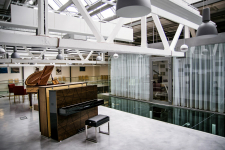 Pro prezentaci klavírů a pianin byla zvolena přístavba u hlavního showroomu na místě původního plechového přístřešku. Přístavbě dominuje celoprosklená plocha severního a východního fasádního pláště.