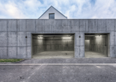 Pohledový beton garáže je doplněn o pohledové pečlivě rozmístěné instalace