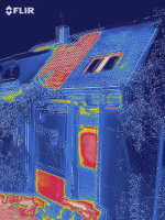 Termosnímek vítězné střechy v horkém létě 2019. Červená a oranžová ukazuje rozpálená místa – část střechy se střešní krytinou a kovové části branky. Naopak v místnosti pod střechou pokrytou vegetací je příjemná teplota