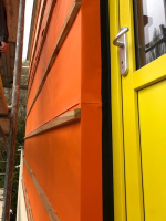 Ochrana zateplené fasády s obkladem s otevřenými spárami. Fotografie ze stavby v rozpracovaném stavu - barva jantarově oranžová (zdroj: Dörken)
