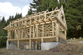 Dřevěná konstrukce stavby stojí na základech z pohledového betonu