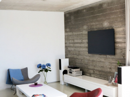 Kombinace hladkých ploch a pohledového betonu vévodí interiéru vyžadujícímu jen minimální údržbu