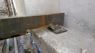 Detail kluzného uložení stropního trámu s úpravou v místě kolize s lanovým ztužením zdiva