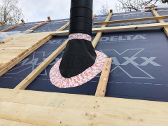 Místa konstrukčních prostupů v místě komína a střešních oken jsou precizně a těsně zajištěna tak, aby se pod fólii nedostala voda ani vítr. Kontralatě oddělují těsně provedenou pojistnou hydroizolaci DELTA-MAXX X od bednění, na které bude přes fólii DELTA-THERM instalována hliníková krytina