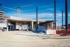 Část severního segmentu mostu autobusového terminálu (pohledem mířícím na sever, vpravo je staniční budova) v části nad kolejištěm, dokončený v místech kolejí, které budou západně od budoucího 4. nástupiště – to se bude nacházet v prostoru pilířů vpravo (foto: Hochtief CZ)
