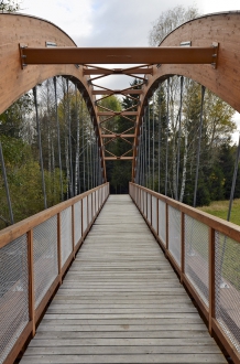 Nosnou konstrukci tvoří oblouk z lepeného lamelového dřeva s dolní mostovkou a šikmými závěsy