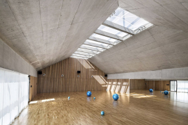 Podlaha haly a akustické obložení stěn jsou dubové, stěny z pohledového betonu. Podhled světlíků byl také akusticky upraven.
